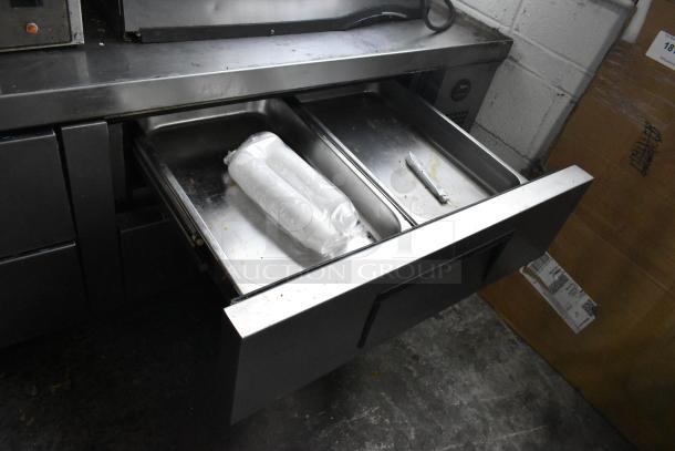 True stainless steel commercial 4-drawer chef base on casters, 115 volts, 1 phase, used condition, open drawers showing storage.