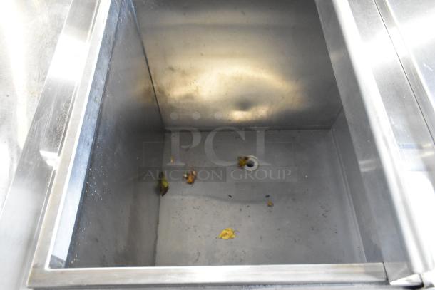 Metal commercial freezer interior with drain, showing wear. Equipped with 115 volts, 1 phase.