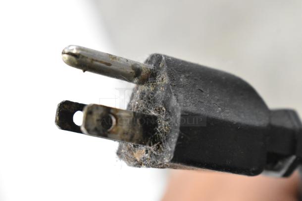 Close-up of a dusty electrical plug from the Leader CVK48 S/C deli display case, showing two prongs and a ground pin.