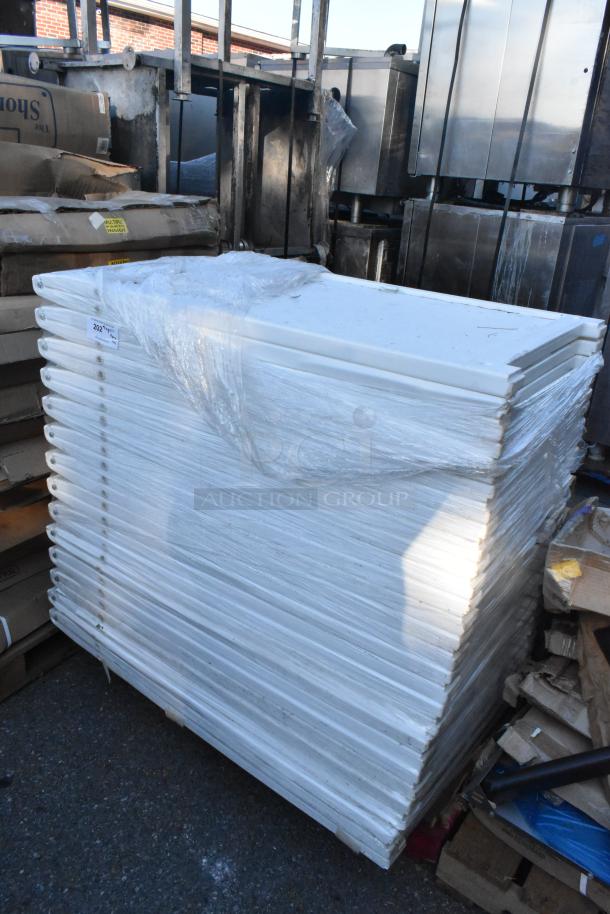 Stack of 44 white poly A-frame sidewalk signs, wrapped in plastic. New condition, ideal for advertising.