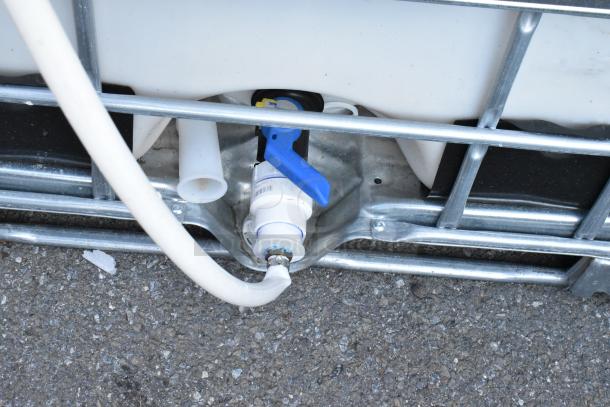 Ecobulk MX275 Tank with metal cage, hose connection, and blue valve handle, in good condition. Model 4004909.