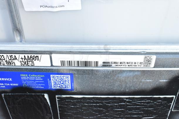 Alt text: "Ecobulk MX275 Tank barcode label, model 4004909, inspection tag, and QR code on metal frame."