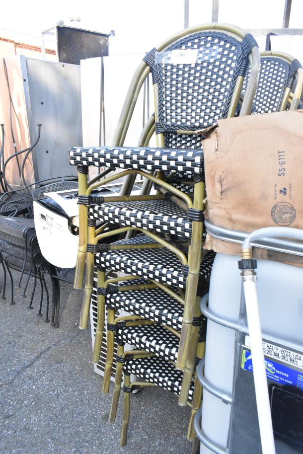 Stack of 12 outdoor wicker-style patio chairs with black and white pattern, metal frame, in good condition. Auction lot 206.