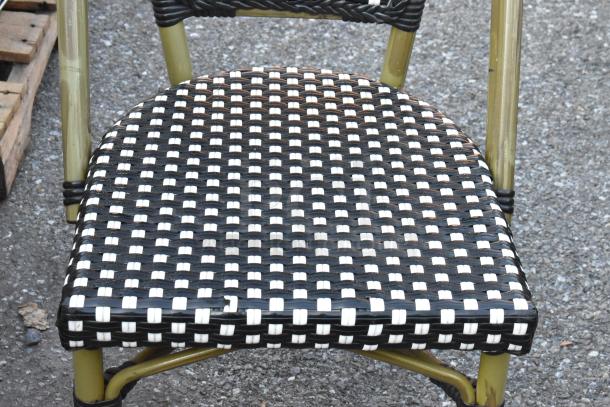Outdoor wicker-style patio chair with black and white woven seat, metal frame, good condition. Auction for 12 chairs.