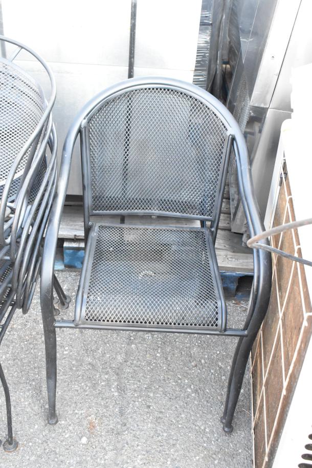 Black metal mesh patio chair, sturdy design, part of a set. Good condition, perfect for outdoor use.