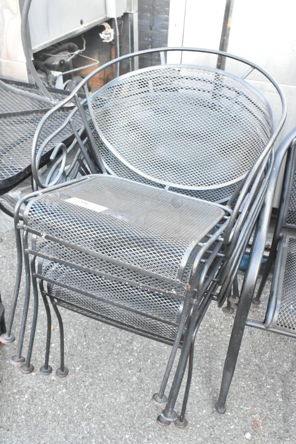 Stacked black metal mesh patio chairs and table, used condition, some wear. Auction for 19 pieces total.