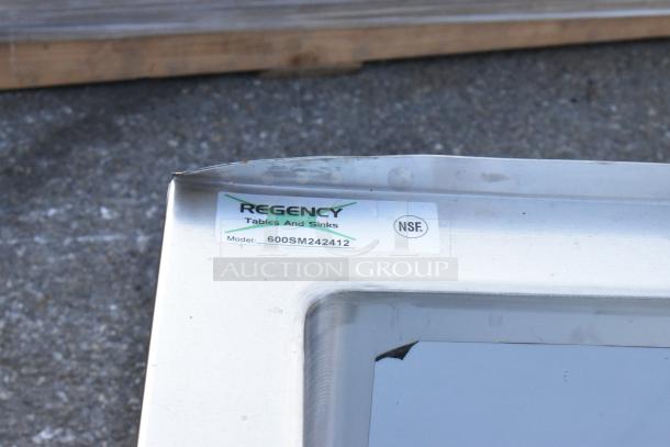 Regency stainless steel sink with visible logo and model number 600SM242412, showing slight dent on corner. NSF certified.