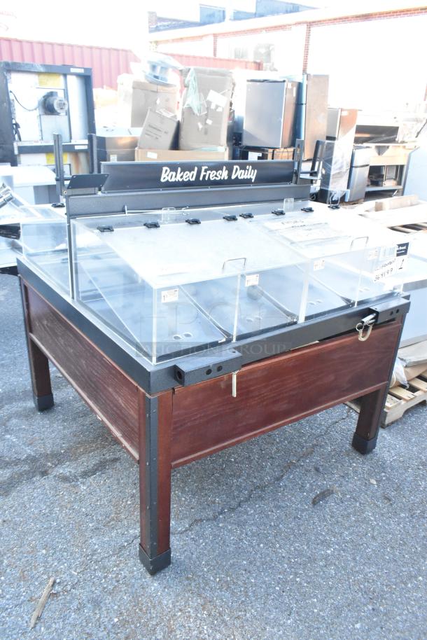 Dry display merchandiser with poly bins, wooden frame, and "Baked Fresh Daily" sign; ideal for bakery items.