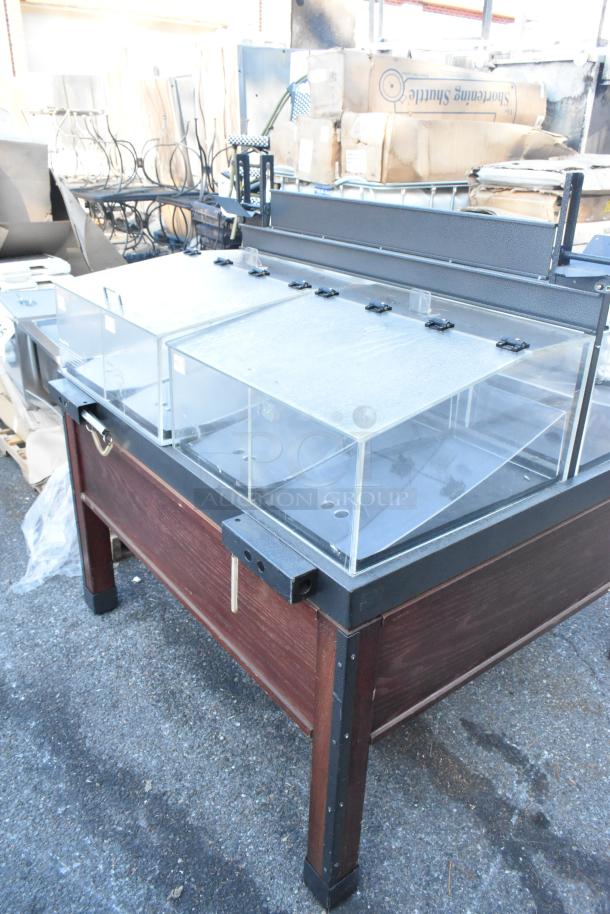Dry display merchandiser with poly bins, featuring a sturdy wooden base and transparent lids, suitable for retail use.
