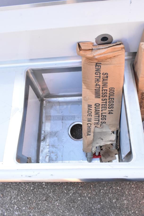 Brand new Regency 600S21717218 stainless steel 2 bay sink with dual drain boards, visible scratches on surface.