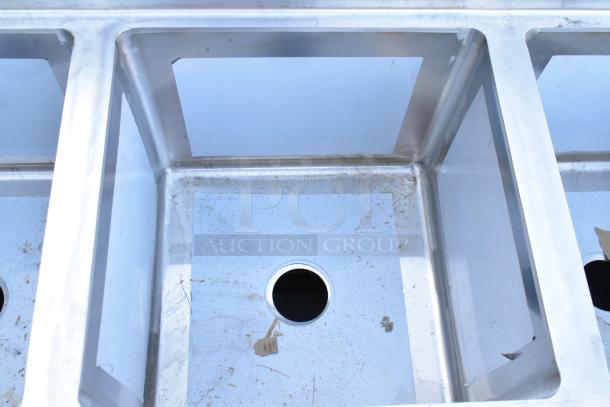 BRAND NEW SCRATCH AND DENT Regency 600S41818218 four-compartment stainless steel commercial sink with two drainboards, no legs.