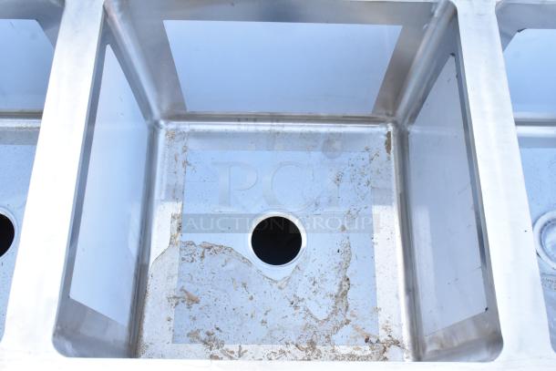 BRAND NEW Regency 600S41818218 16 Gauge Stainless Steel Four Compartment Sink with Two Drainboards, no legs, visible scratches.