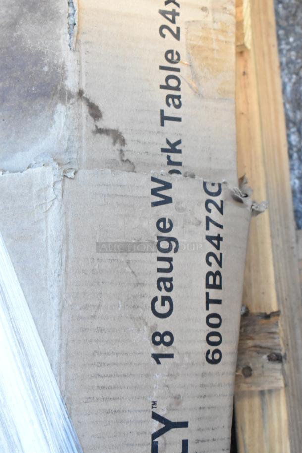 Box labeled "600TB2472G Regency 18 Gauge Work Table," shows signs of wear. Contains new stainless steel work table.