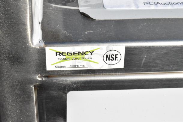 "Regency 600PB74S stainless steel portable bar with NSF label, showing model number and minor dent on surface."