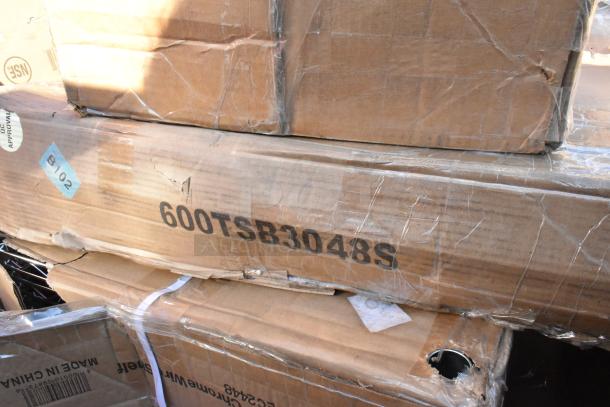 Stacked boxes labeled "600TSB3048S" showing signs of wear, part of an auction lot including Lavex dolly and Regency table.