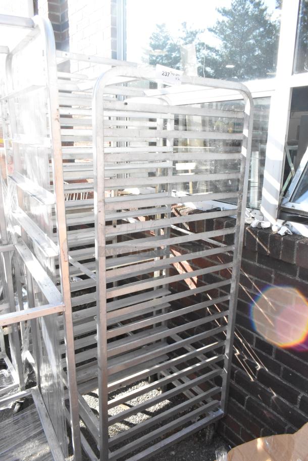 2 metal pan transport racks on commercial casters, sturdy condition, ideal for kitchen use, numbered tag visible.