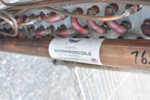 Nationwide Coils evaporator coil with copper tubing and label showing brand name and contact info, in good condition.
