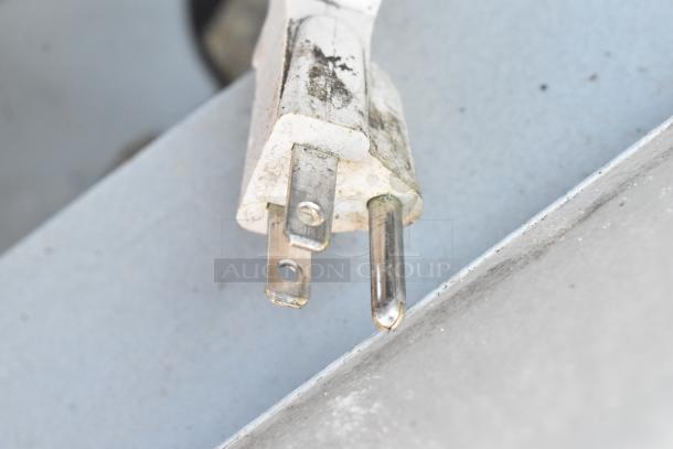 Close-up of a three-pronged electrical plug showing signs of wear and dirt, part of the Duke SUB-HJF-R25 warming station.