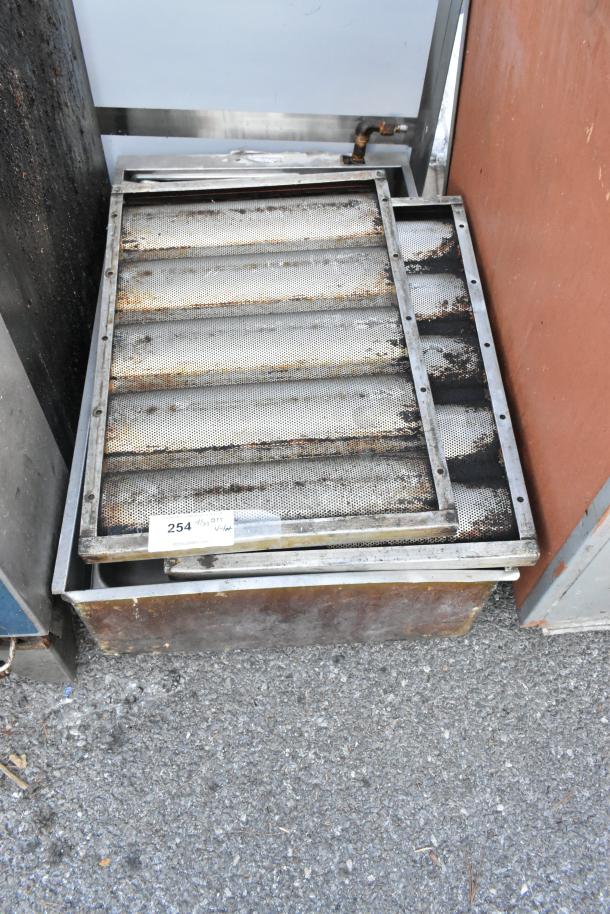 Lot of various items including metal grease hood filters, showing signs of wear and rust. Auction tag labeled "254."