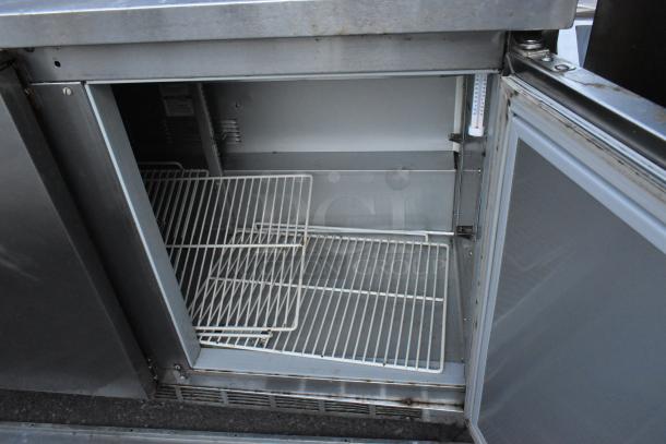 Beverage Air SPE72HC-18 stainless steel prep table, open door showing interior shelving, commercial casters, 115V, 1 phase.