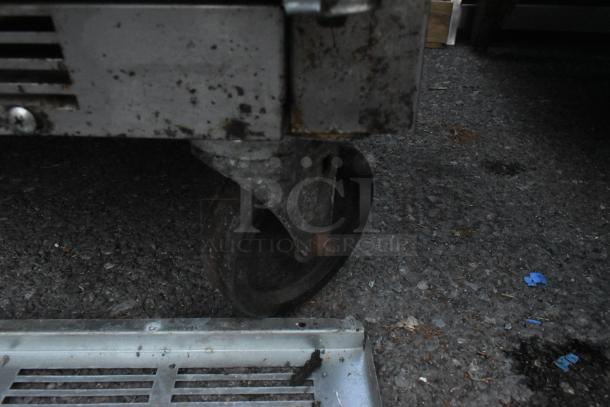 Beverage Air SPE72HC-18 prep table on commercial caster; visible wear with rust on casters, stainless steel finish.