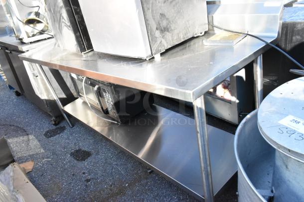 Stainless steel table with metal under shelf; sturdy construction, minimal wear. Ideal for kitchen use. No visible markings.