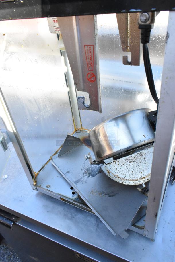 Galaxy 177POP8 metal countertop popcorn machine. Visible wear and residue inside. 120V, 1 phase. Caution labels present.