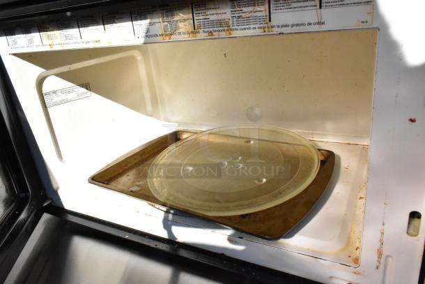 Magic Chef MCO160UB countertop microwave oven with glass plate, shows signs of wear, 120 volts, 1 phase.