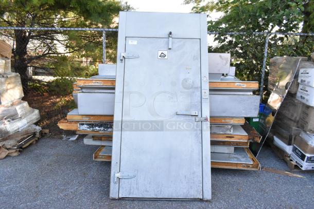 Harford walk-in box door with Bohn 115V, 1-phase evaporator fan. Visible hinges and latch, resting on pallets.