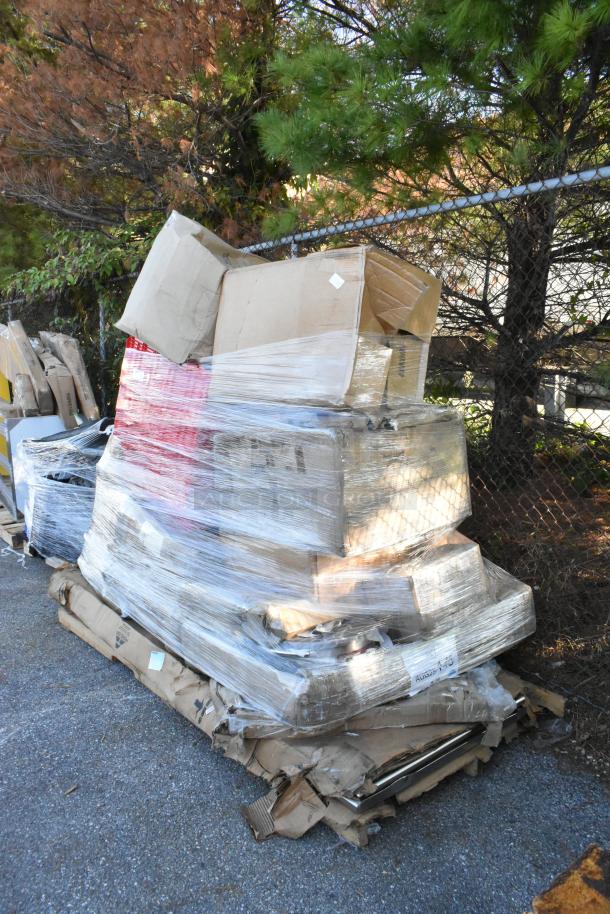 Stack of 16 brand new scratch and dent items, including garbage disposer, mop sink, and shelf warmer, wrapped in plastic.