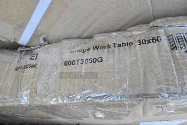 Cardboard box labeled "600T3060G Gauge Work Table 30x60," part of a new scratch and dent auction lot.