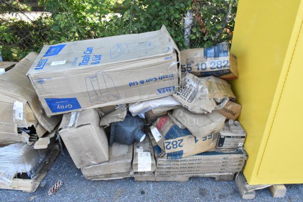 Boxes of brand new scratch and dent items including a gray trash can, towel dispensers, and soup bowls.