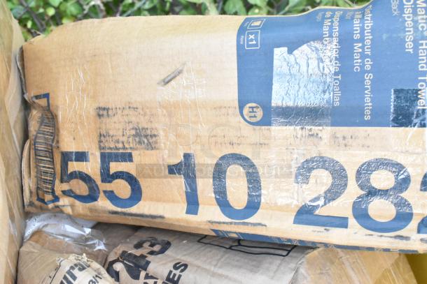 Cardboard box containing scratch and dent items. Visible markings include "Matic Hand Towel Dispenser" and numbers "5510282."