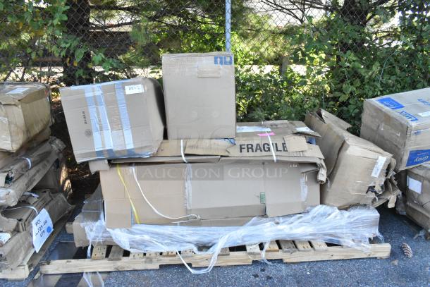 Six brand new scratch and dent items including a table and wall cabinet, packaged on a wooden pallet, visible "Fragile" label.