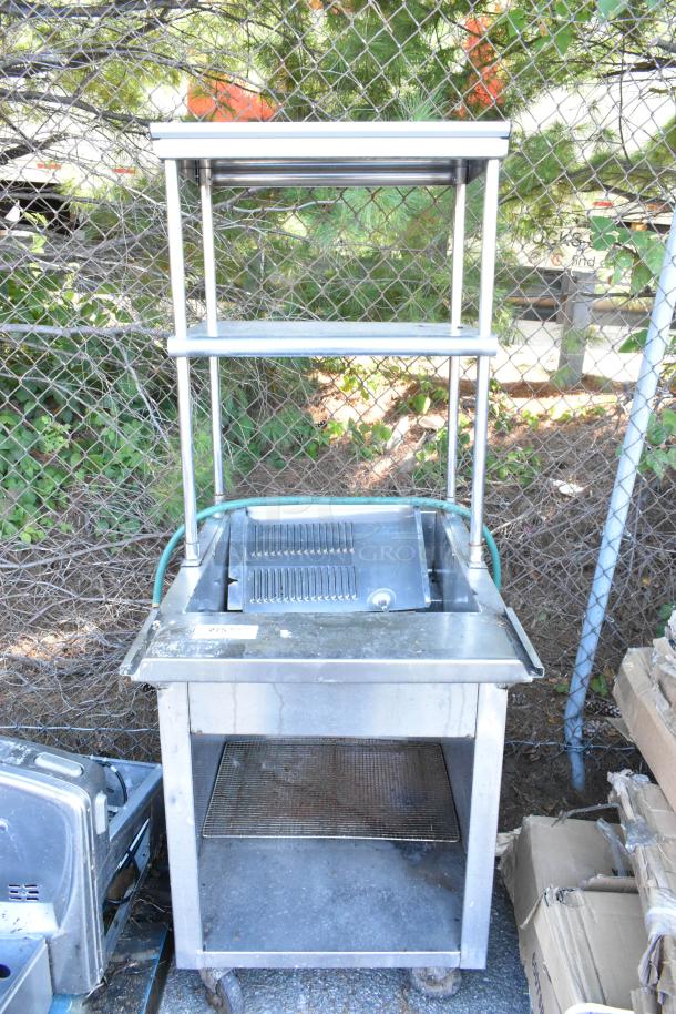 Stainless steel steam table with 2-tier over shelf, metal under shelf, on commercial casters. Visible wear.