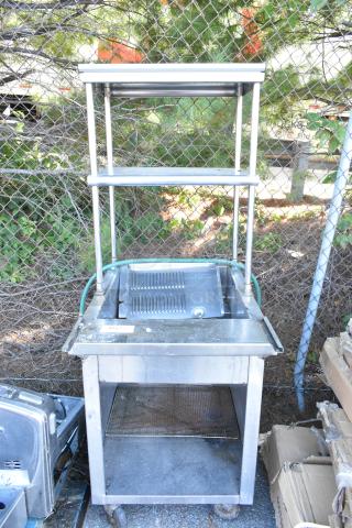 Stainless steel steam table with 2-tier over shelf, metal under shelf, on commercial casters. Visible wear.