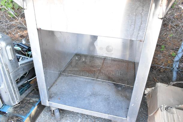 Stainless steel steam table with a 2-tier over shelf and metal under shelf on commercial casters, showing signs of use.