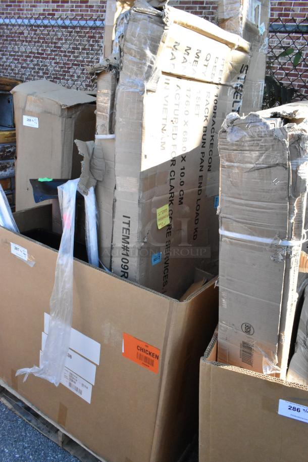 11 new Seaga items with minor scratches and dents, including pan racks, in labeled boxes.