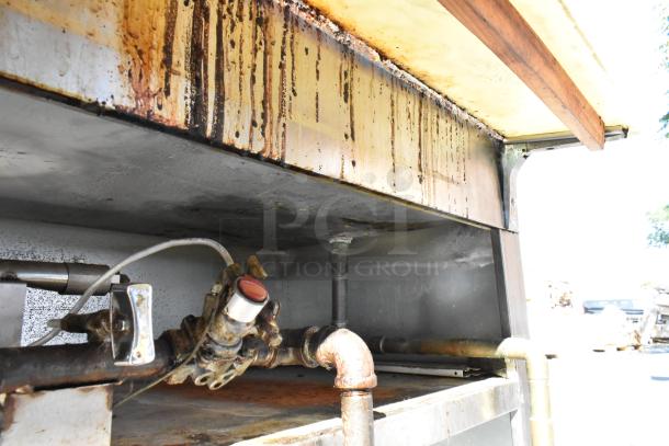Stainless steel commercial steam table with visible rust and wear, featuring a sneeze guard and under shelf, used condition.