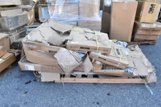 Six brand new boxed items, including Lancaster gray umbrella bases and work tables, on a wooden pallet. Boxes appear intact.