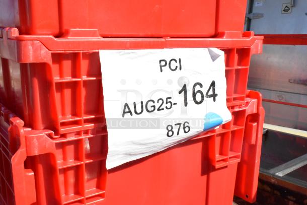 Red storage bins labeled "PCI AUG25-164 876," part of a scratch and dent auction lot including shelf, chafer, tables, and cutting board.