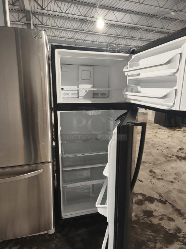 Frigidaire FFTR1821TB black top freezer refrigerator, 18 cu. ft., open, showing interior shelves and compartments. Model FFTR1821TB0.