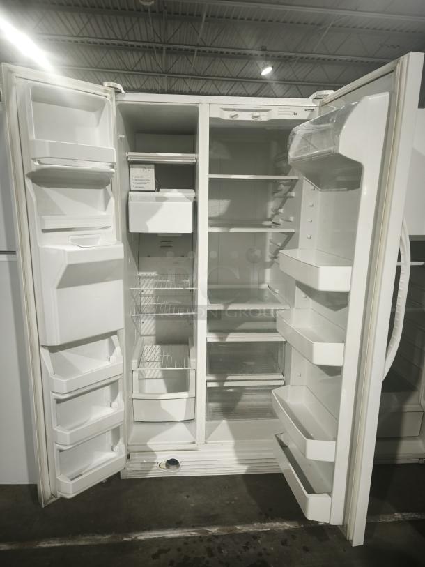 Kenmore refrigerator, model 10657362700. White, side-by-side doors open, revealing shelving and door compartments. Good condition.