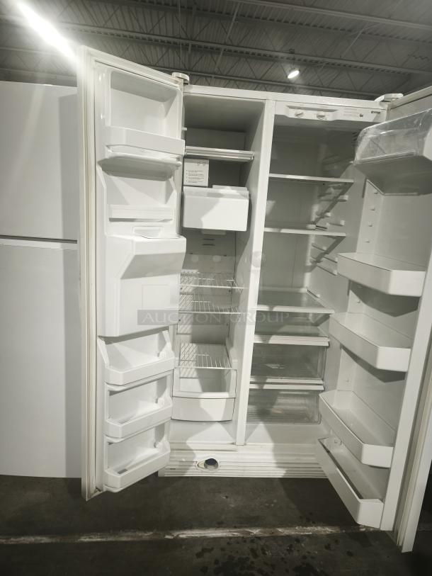 Kenmore Coldspot refrigerator model 10657362700, white, doors open, inside shelves and compartments visible, in used condition.