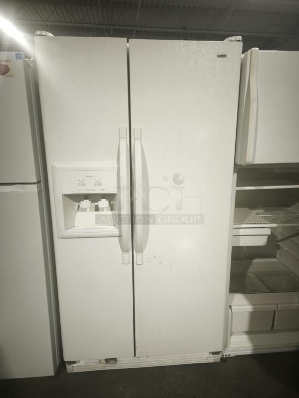 Kenmore refrigerator, model 10657362700, white, side-by-side doors, visible wear marks, built-in water dispenser.