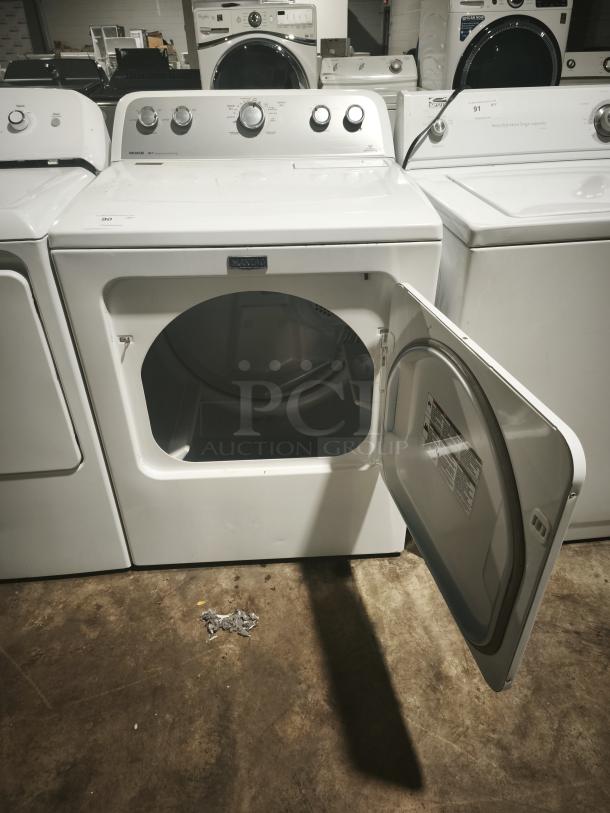 White MAYTAG 7.0 cu. ft. dryer, model MEDX655DW, features a sanitize cycle. Open door shows interior. Good condition.