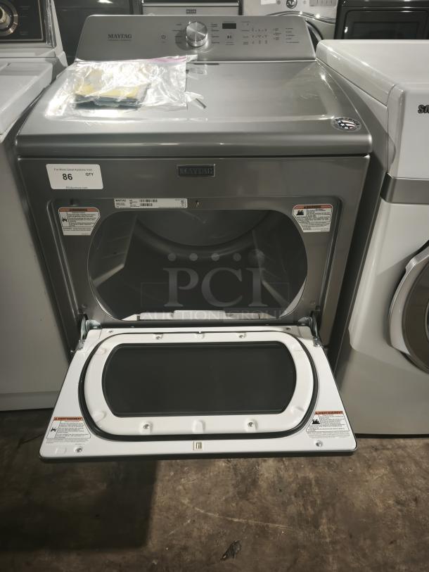 MAYTAG 27" electric dryer, model MEDB765FC0, in metallic slate with IntelliDry® Sensor, open door, auction lot tag visible.