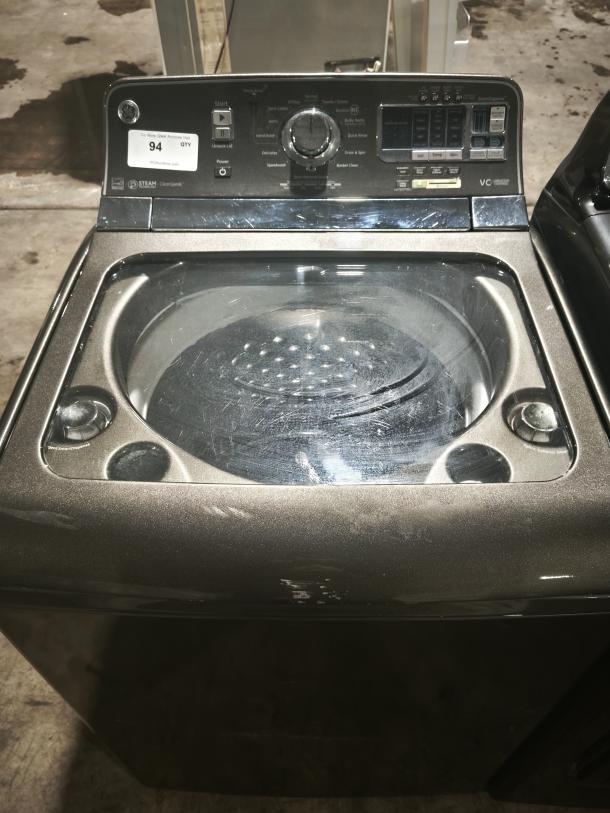 GE® 5.0 cu. ft. washer model GTWS8655D0MC with stainless steel basket, visible control panel, tags indicating model and condition.
