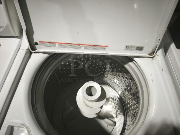 GE High Efficiency Agitator Medium Top-Load Washer GTW485ASWWB in white, open lid, showing interior drum and agitator, visible usage wear.