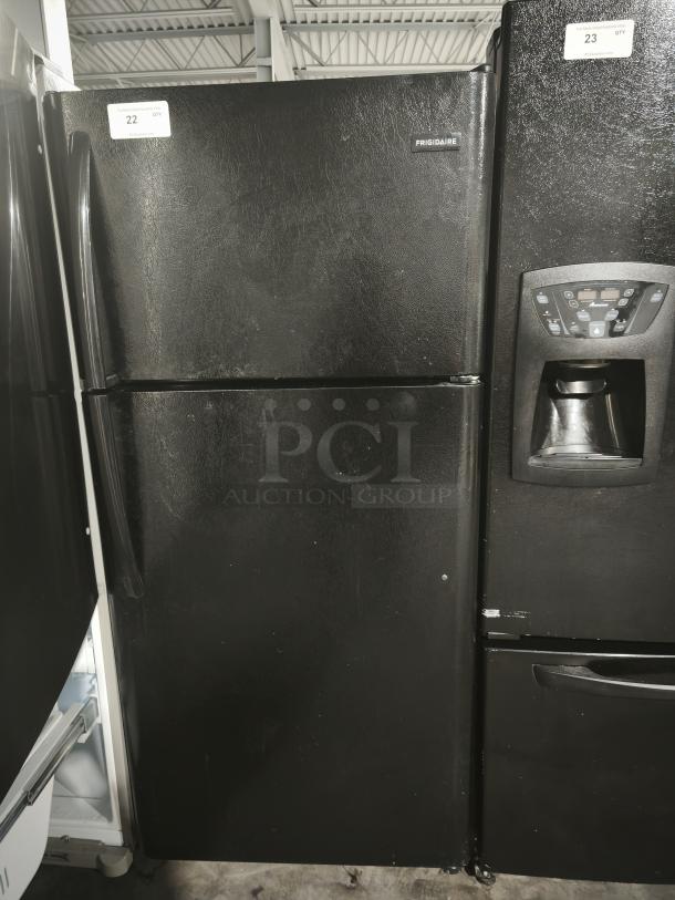 Frigidaire FFTR1821TB 18 Cu. ft. black top freezer refrigerator, model FFTR1821TB0, used condition, visible wear, auction label "22".
